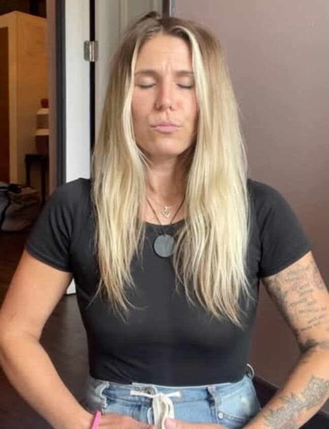 Kendra Kozub sitting in stillness with her eyes closed during a breathwork practice